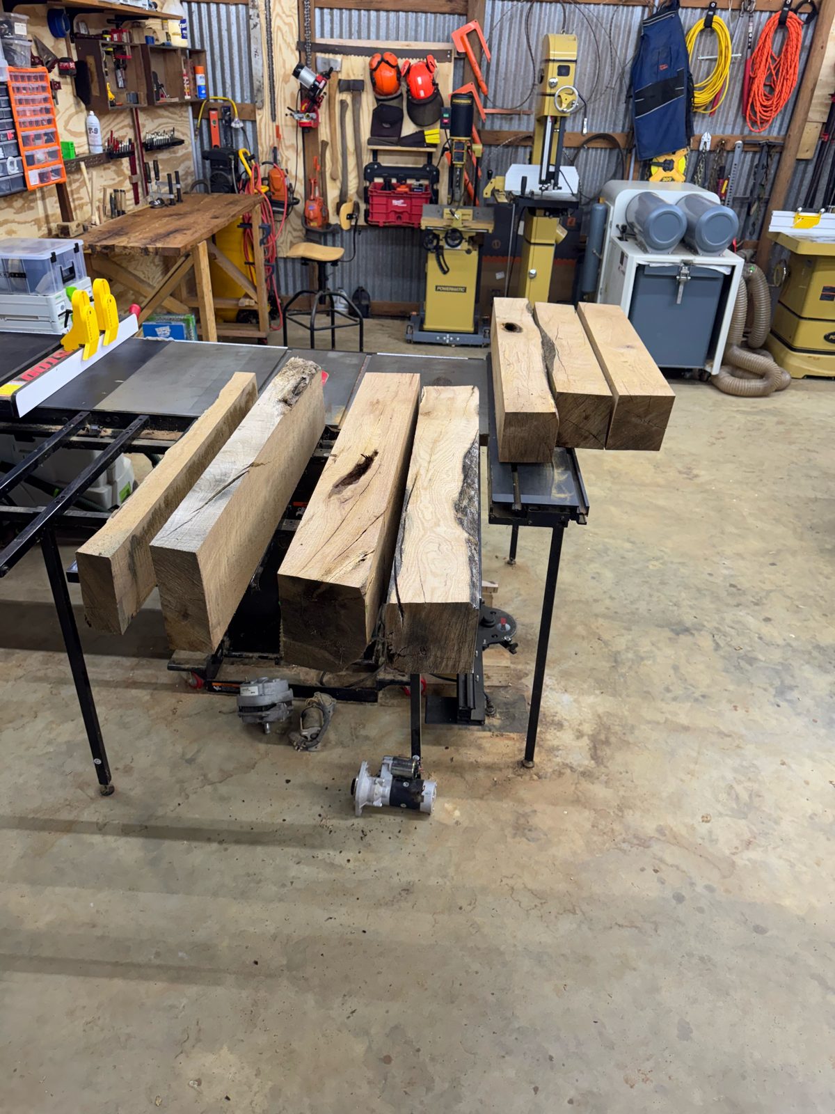 Thick rough-sawn oak timbers on the table saw